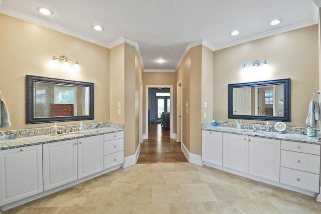 bathroom with recessed lighting, a sink, crown molding, two vanities, and baseboards