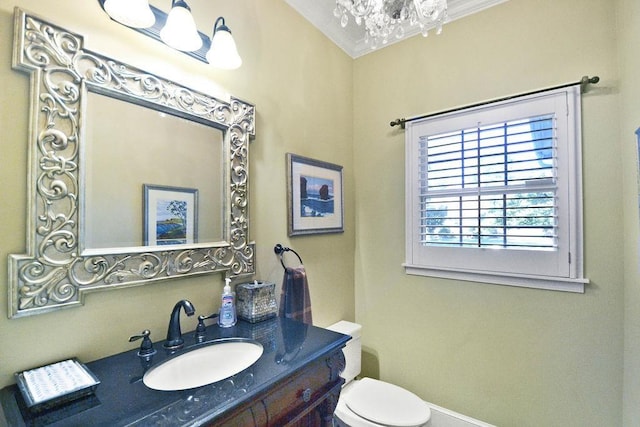 half bathroom featuring toilet, a chandelier, vanity, and baseboards
