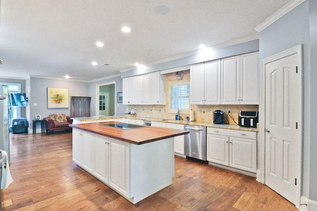kitchen featuring recessed lighting, butcher block countertops, ornamental molding, dishwasher, and white cabinetry
