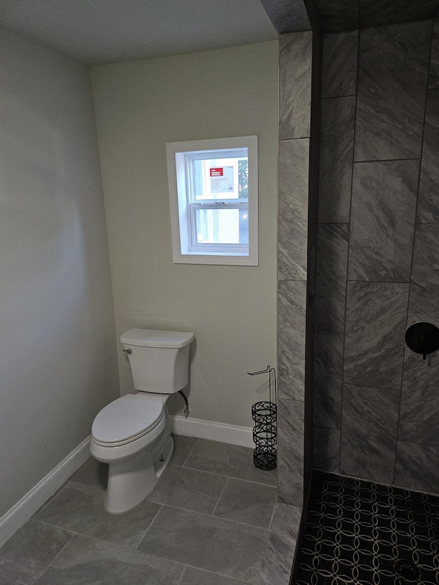 bathroom featuring tiled shower, toilet, and tile patterned floors