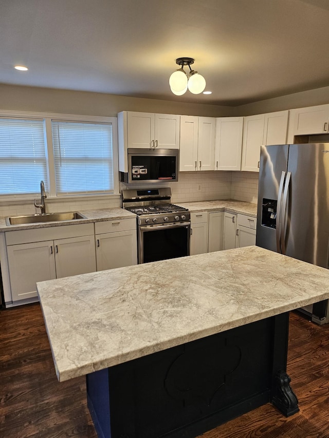 kitchen with white cabinetry, stainless steel appliances, sink, and dark hardwood / wood-style floors