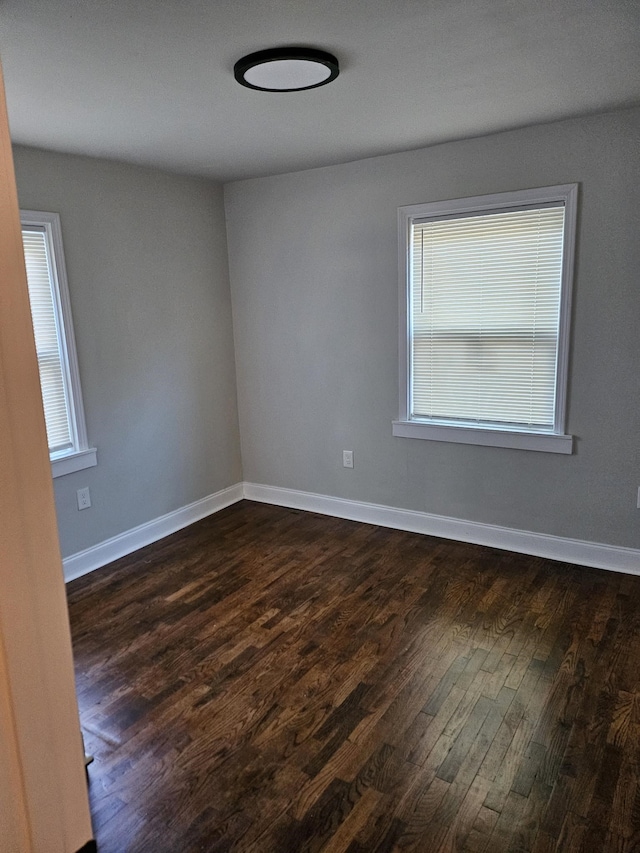 unfurnished room with dark wood-type flooring