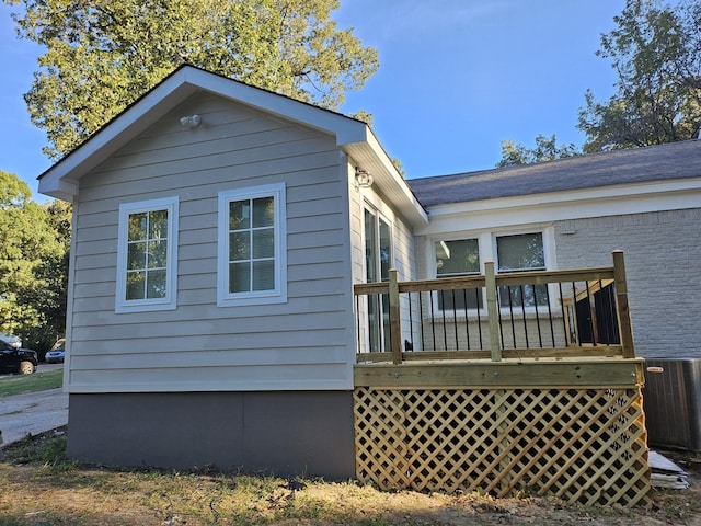 view of property exterior with central air condition unit and a deck