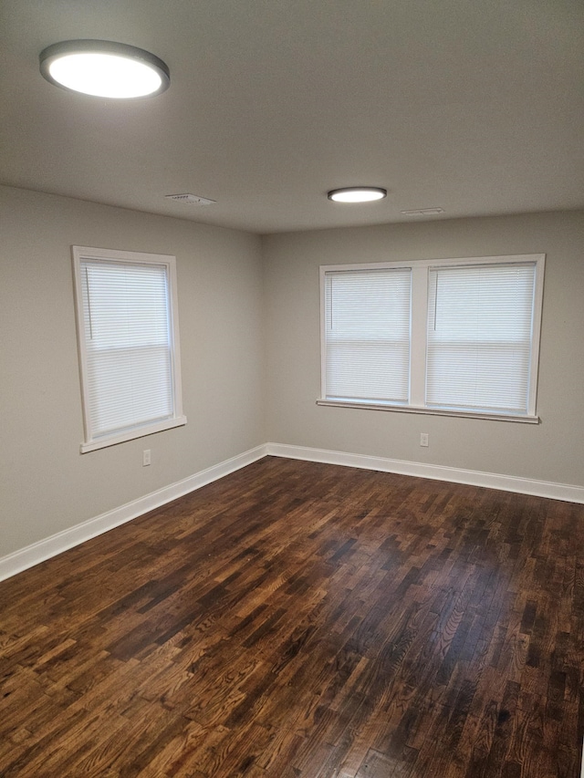 unfurnished room with dark wood-type flooring