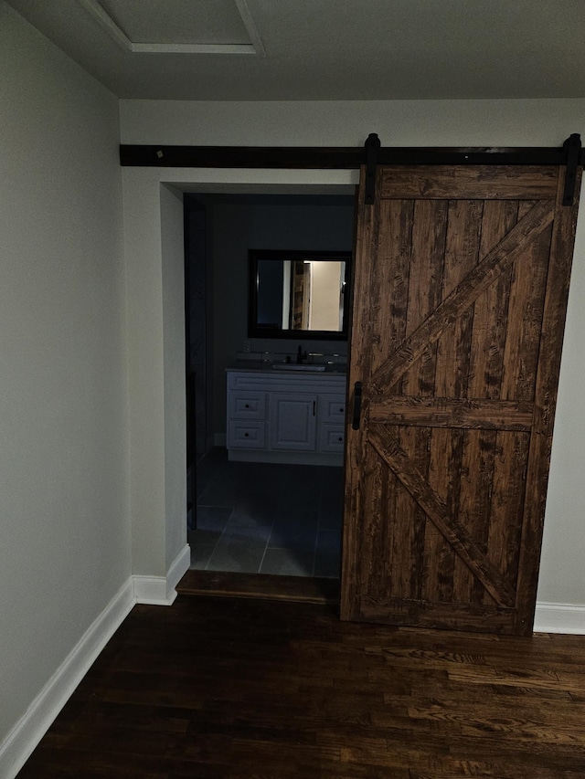 hall featuring dark hardwood / wood-style floors, sink, and a barn door