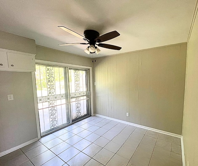 tiled spare room featuring ceiling fan