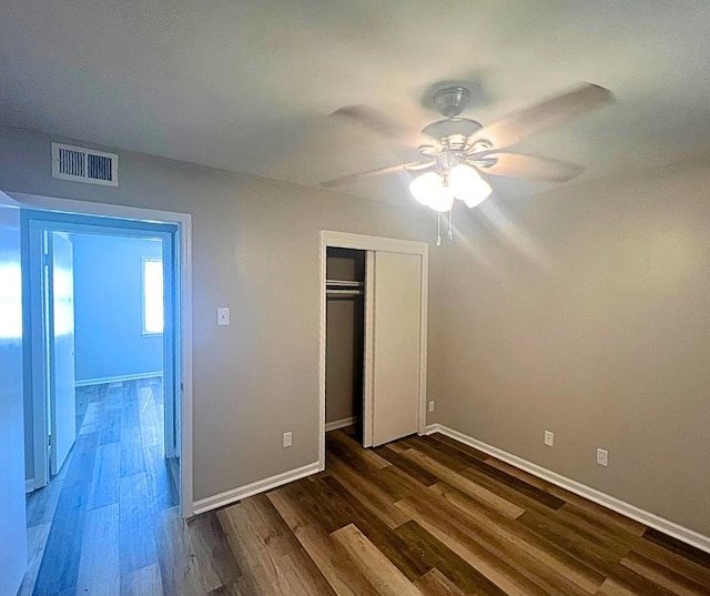 unfurnished bedroom featuring a closet, ceiling fan, and dark hardwood / wood-style flooring