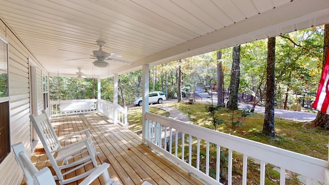 wooden deck featuring covered porch and ceiling fan