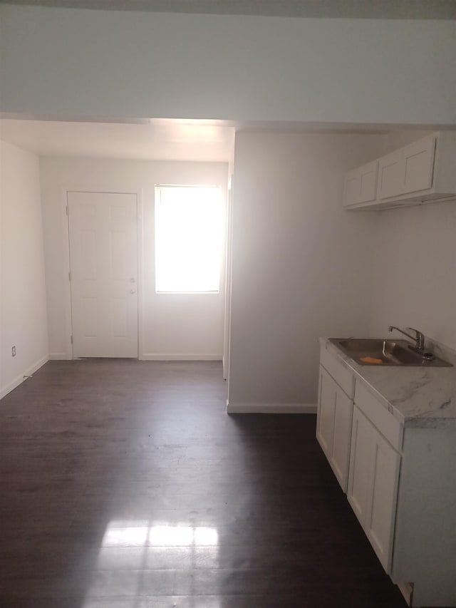 kitchen with sink, white cabinets, and dark wood-type flooring