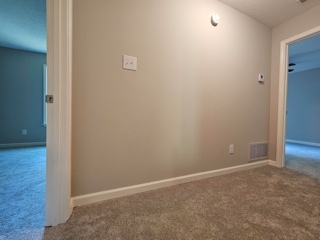 corridor featuring a textured ceiling and carpet floors