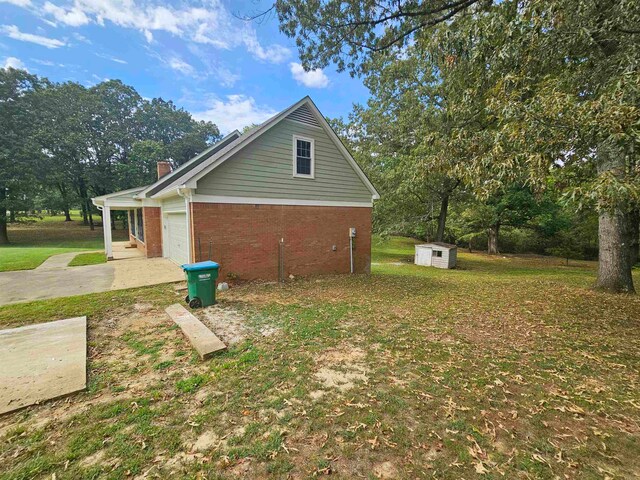 view of side of home featuring a garage and a lawn