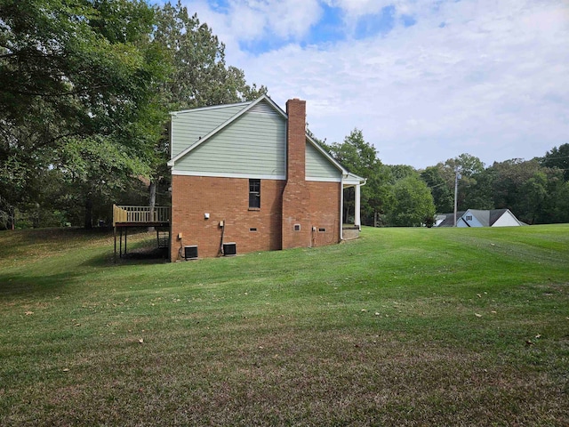 view of side of property featuring a yard and a wooden deck