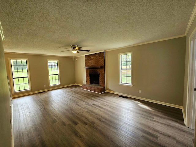 unfurnished living room with a healthy amount of sunlight, a textured ceiling, dark hardwood / wood-style flooring, and a fireplace