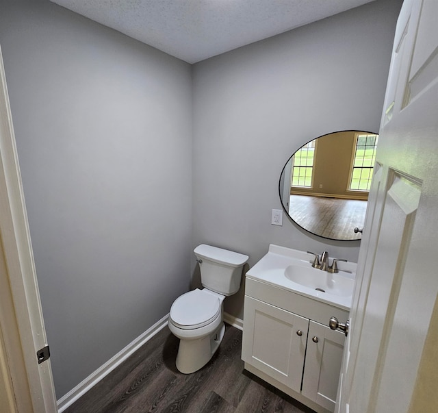 bathroom featuring toilet, a textured ceiling, vanity, and wood-type flooring