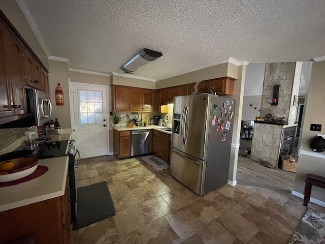 kitchen featuring backsplash, stainless steel appliances, ornamental molding, and a textured ceiling