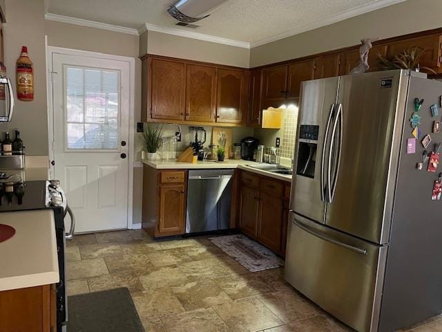 kitchen featuring stainless steel appliances, ornamental molding, a textured ceiling, and decorative backsplash