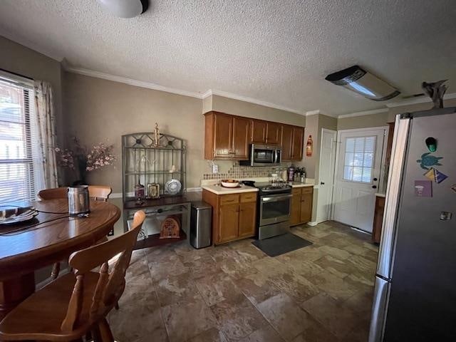 kitchen featuring ornamental molding, appliances with stainless steel finishes, a textured ceiling, and tasteful backsplash