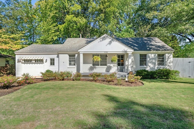 ranch-style home featuring a porch, a front yard, and a garage