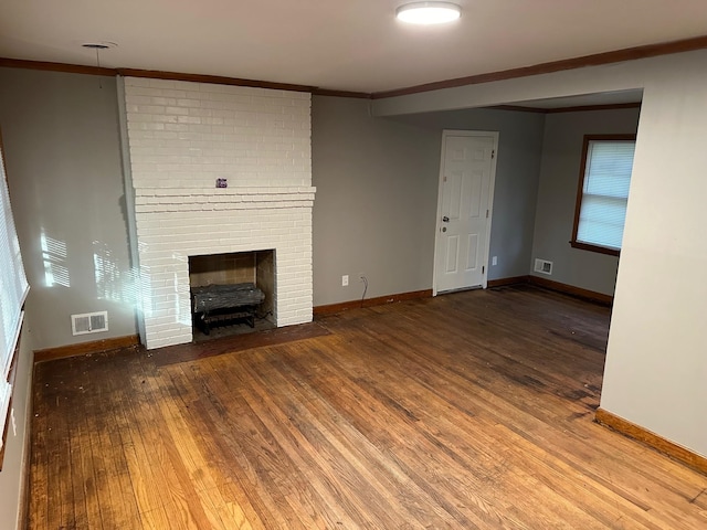 unfurnished living room with crown molding, a fireplace, and wood-type flooring