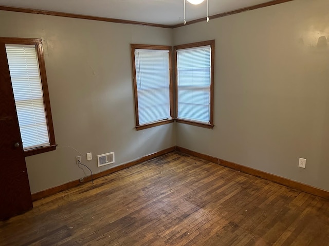 empty room with crown molding, dark wood-type flooring, and ceiling fan