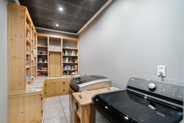 laundry room featuring washer and clothes dryer and light tile patterned floors