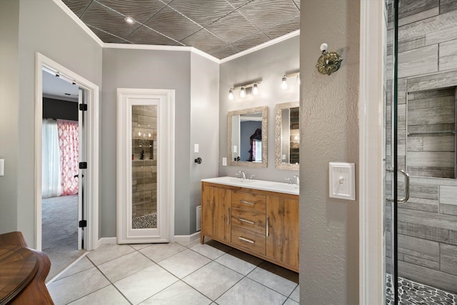 bathroom featuring vanity, crown molding, walk in shower, and tile patterned floors