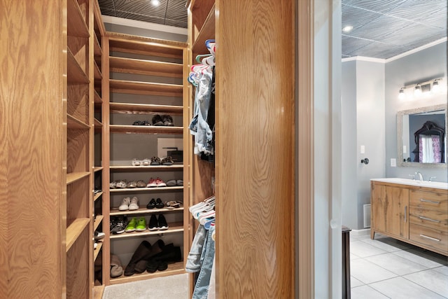 walk in closet with sink and light tile patterned floors