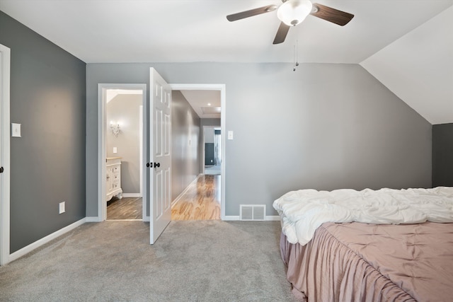 carpeted bedroom featuring ensuite bath, vaulted ceiling, and ceiling fan