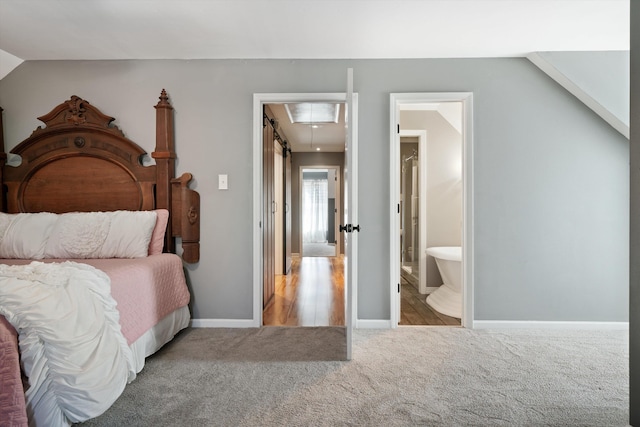 bedroom featuring lofted ceiling, carpet, and ensuite bathroom