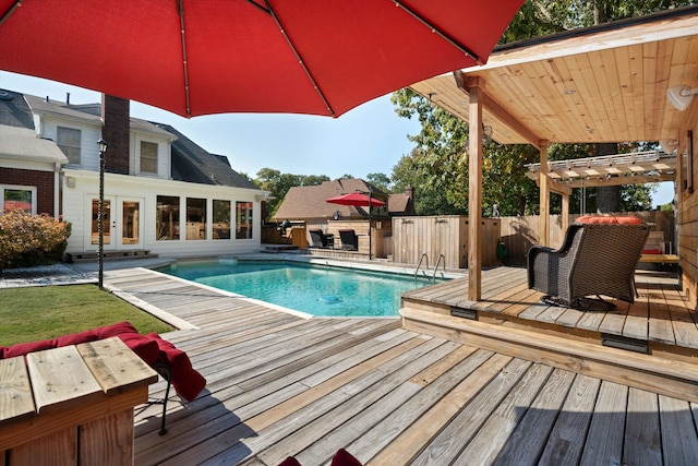 view of swimming pool featuring a wooden deck, french doors, and a pergola