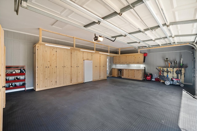 garage with a garage door opener and white fridge