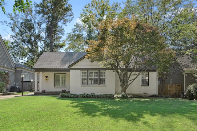 view of front of home with a front lawn and central AC