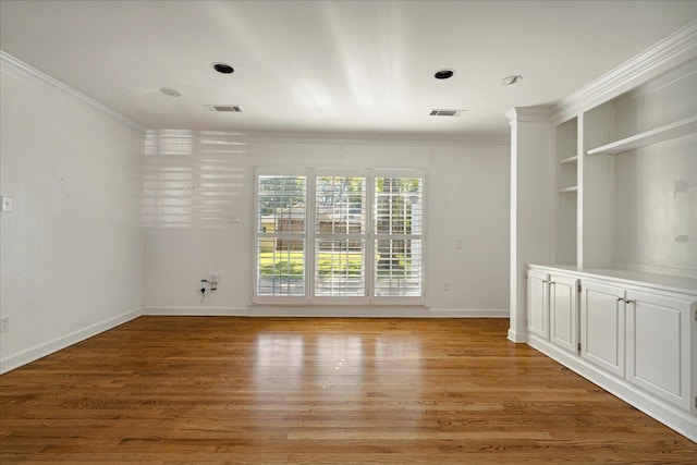 spare room featuring crown molding and light hardwood / wood-style floors