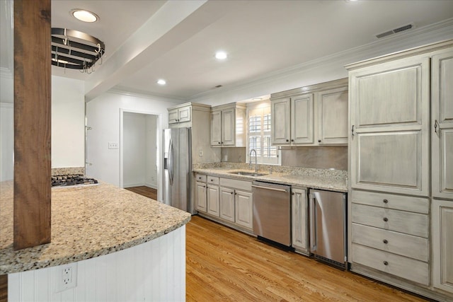 kitchen with light stone countertops, sink, light hardwood / wood-style flooring, and stainless steel appliances