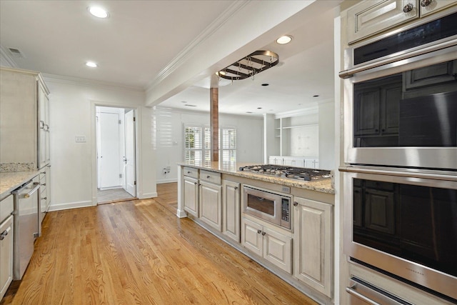 kitchen with light stone countertops, appliances with stainless steel finishes, light hardwood / wood-style flooring, and ornamental molding