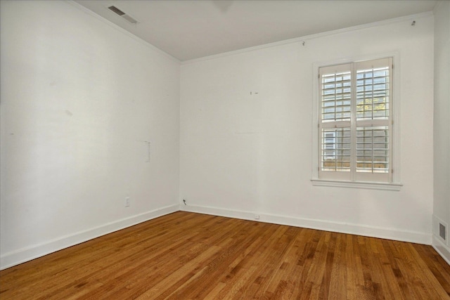 empty room with wood-type flooring and ornamental molding