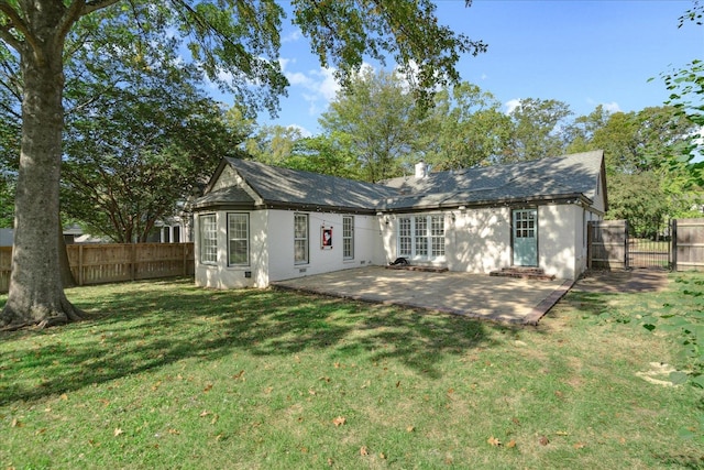 back of house with a patio area and a lawn