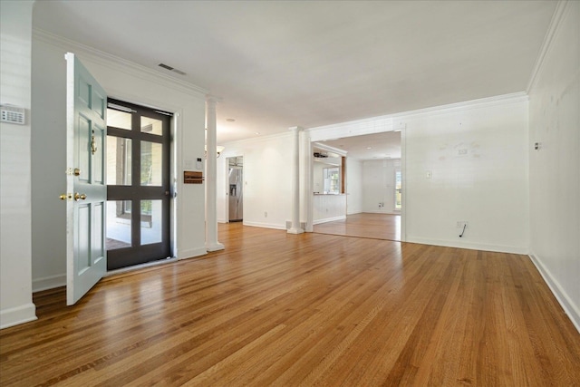 empty room with ornamental molding and light wood-type flooring