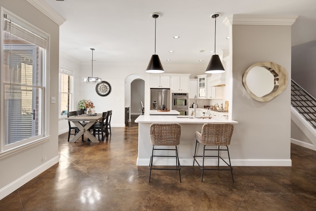 kitchen featuring decorative backsplash, white cabinetry, ornamental molding, decorative light fixtures, and stainless steel appliances