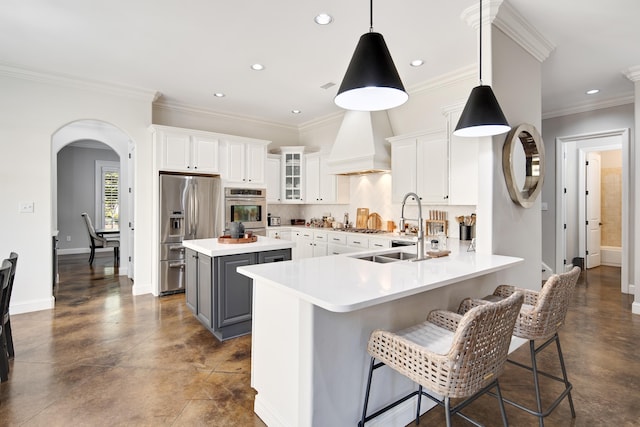 kitchen featuring a kitchen island, a breakfast bar area, hanging light fixtures, white cabinets, and appliances with stainless steel finishes