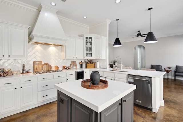 kitchen with appliances with stainless steel finishes, custom exhaust hood, white cabinets, and hanging light fixtures