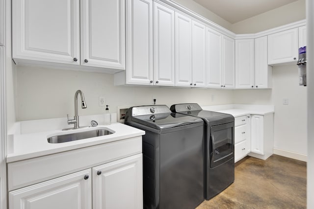 laundry room featuring cabinets, sink, and washing machine and clothes dryer