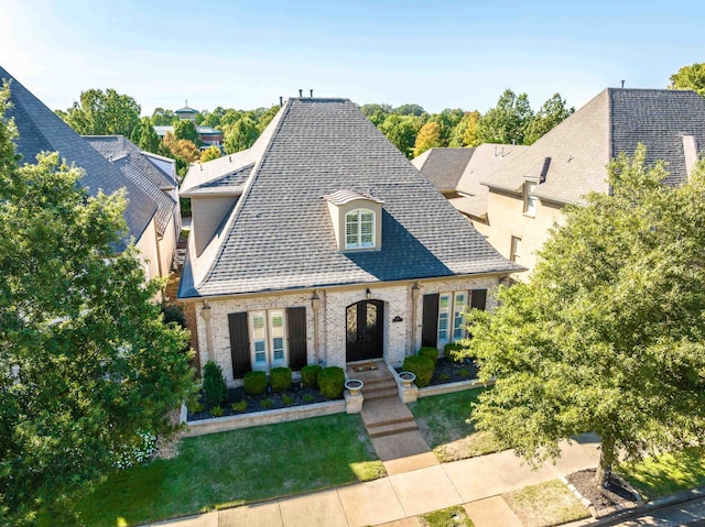 french provincial home featuring a front yard