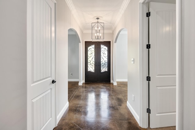 entryway featuring a notable chandelier, ornamental molding, and dark hardwood / wood-style floors