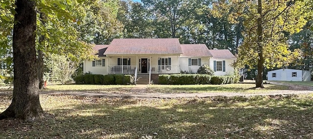 ranch-style house with covered porch and a front lawn