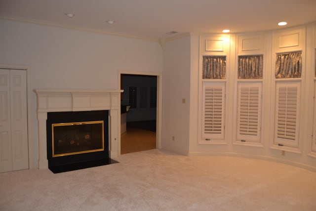 unfurnished living room with ornamental molding and carpet floors