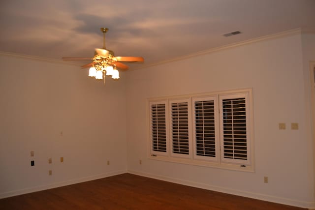 empty room featuring ceiling fan, crown molding, and dark hardwood / wood-style floors