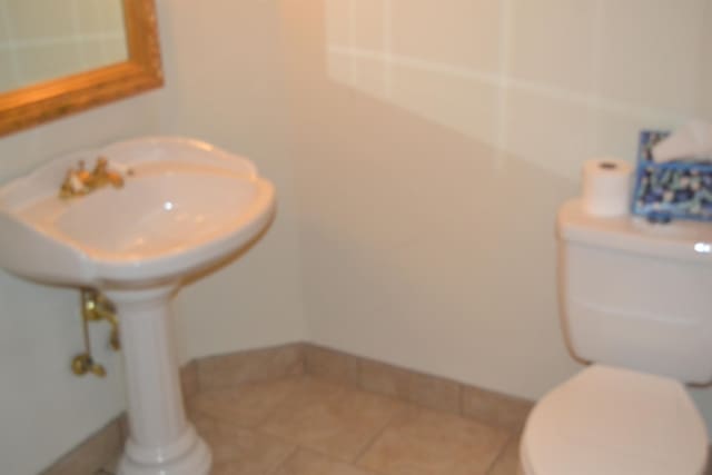 bathroom featuring toilet and tile patterned flooring