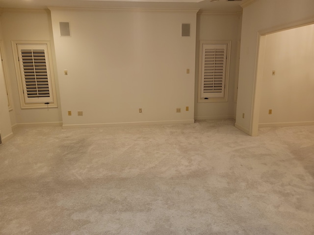 carpeted spare room featuring crown molding