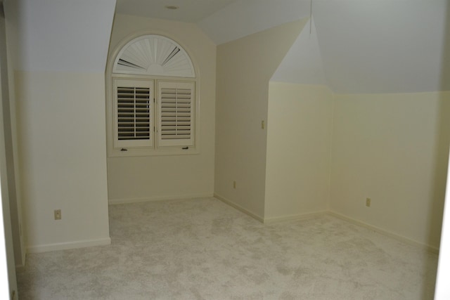 interior space with light carpet and lofted ceiling